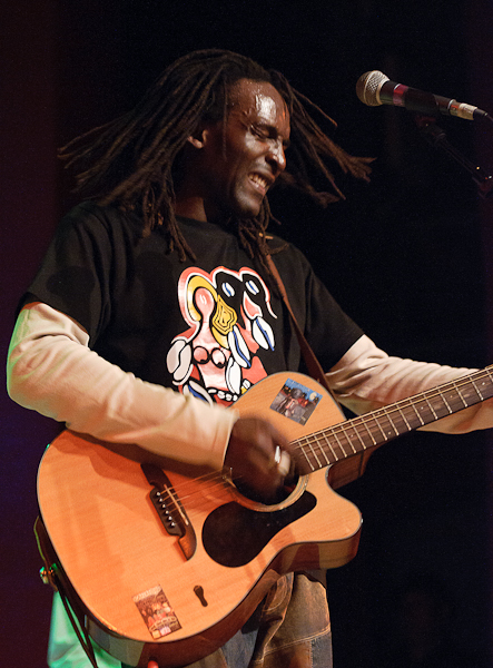 Le chanteur secoue la tête en jouant de la guitare